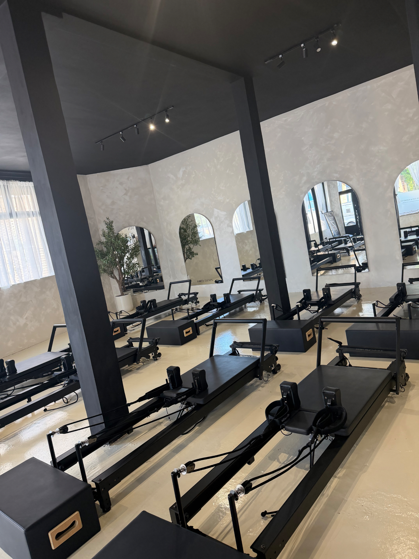 Woman on a reformer, mid-flow, side profile