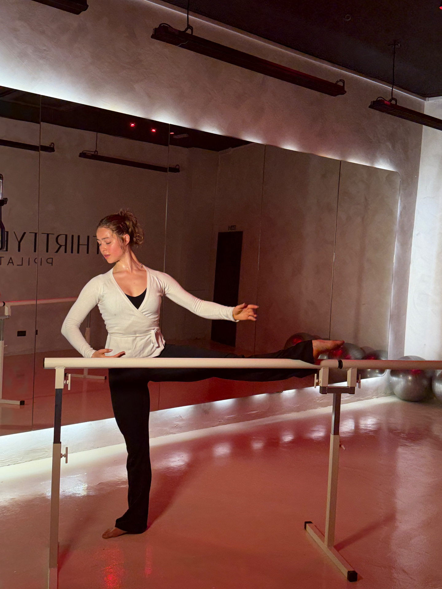 Woman at a ballet barre, plié, calm posture